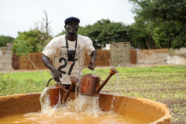Homme prenant de l'eau dans des arrosoirs