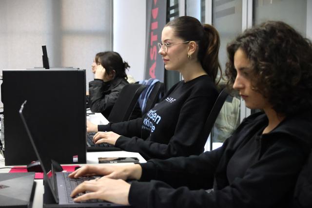 Young ladies at a workshop working on computers to upskill for the AI era