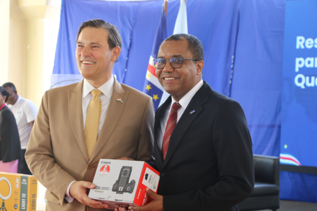 Two men holding the box of a new camera
