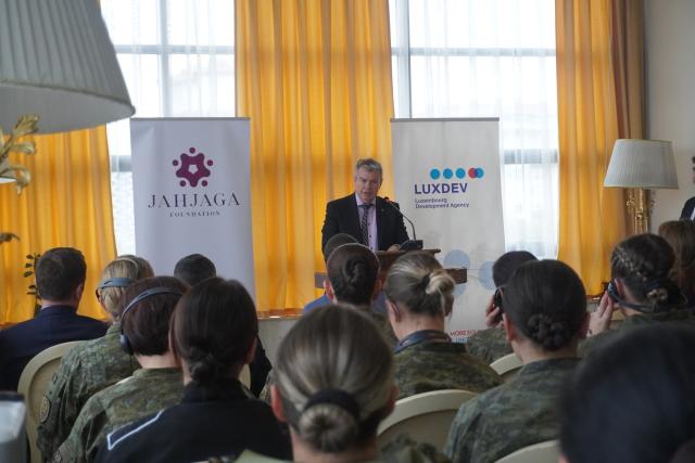 Ambassador speaking at a booth during certification ceremony