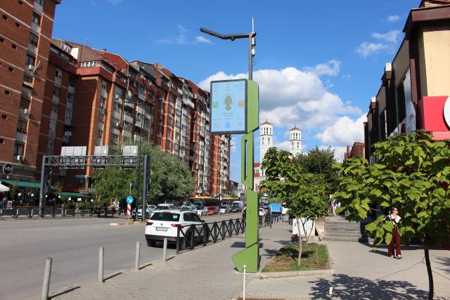 A street in a city center, with a pole in the middle