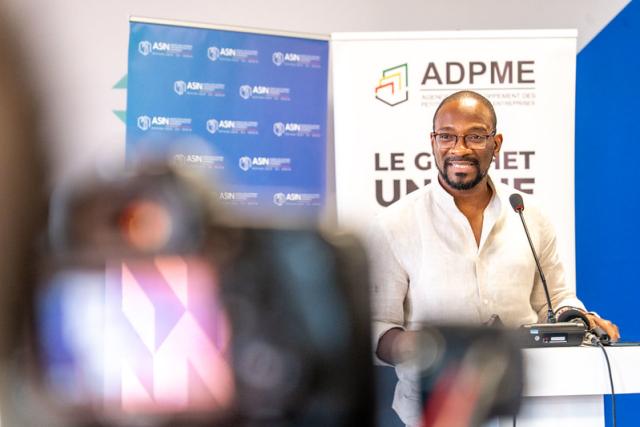 Homme s'exprimant derrière un pupitre