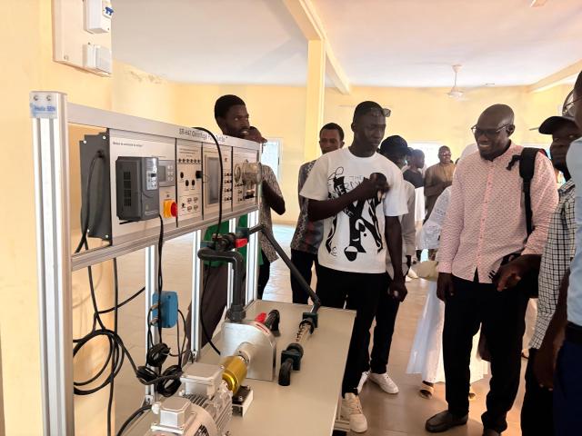 Groupe de personnes assistant à une démonstration d'équipement pour l'apprentissage des métiers de l'électricité