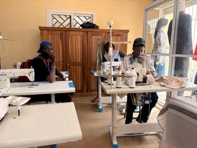 Apprenants devant des tables de couture