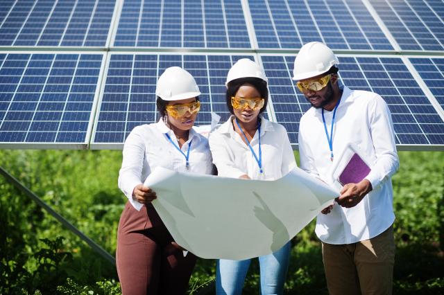 Équipe de jeunes femmes et homme sur un site photovoltaïque