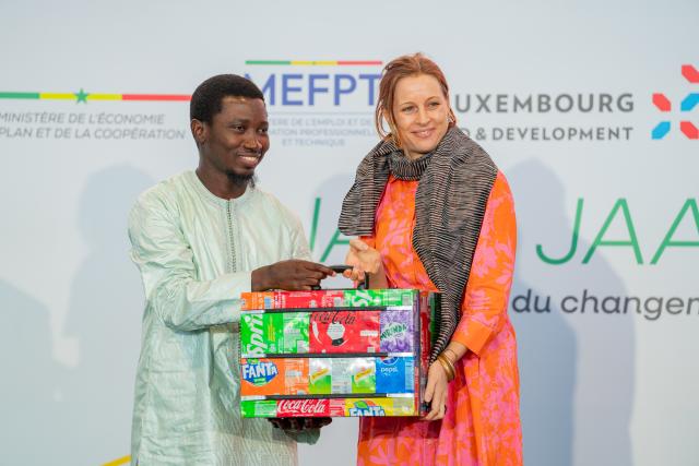 Femme remettant à un homme une valise en matériaux recyclés