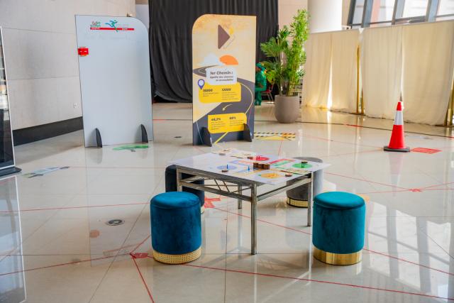 Table et tabourets au centre d'un parcours d'exposition