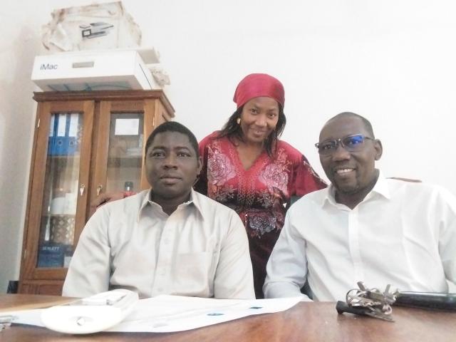 Trois personnes prenant la pose dans une salle de réunion