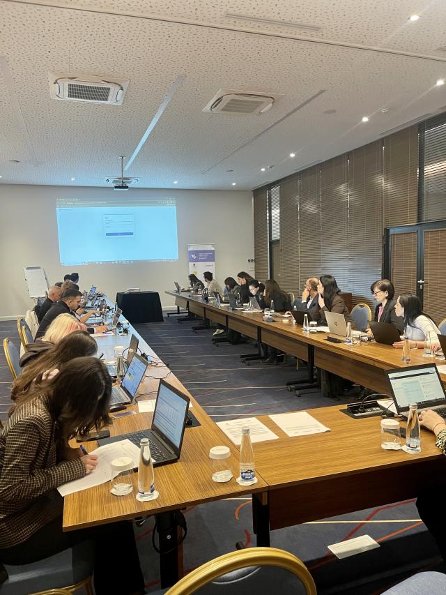 Workshop room with participants following a presentation on the screen