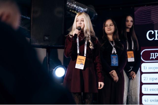 17-year-old girl holding a microphone on a stage