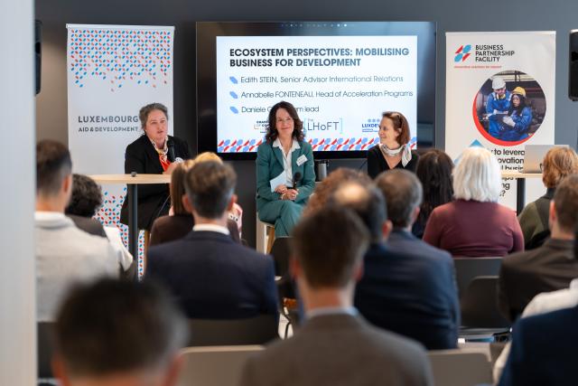 Three ladies in a panel discussion in front of an audience